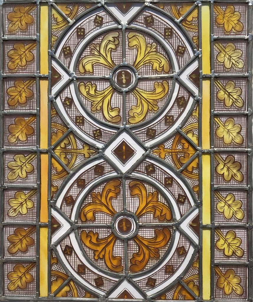 Panneau de vitrail traditionnel aux tons dorés et motifs végétaux
